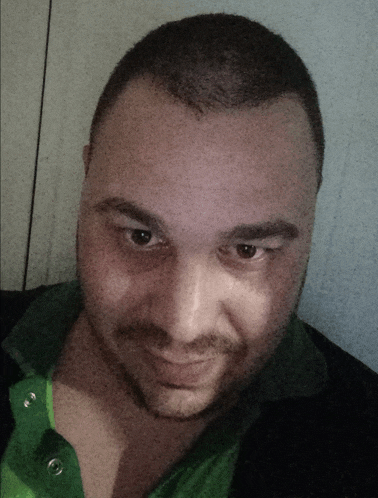a man with a beard and a green shirt is smiling