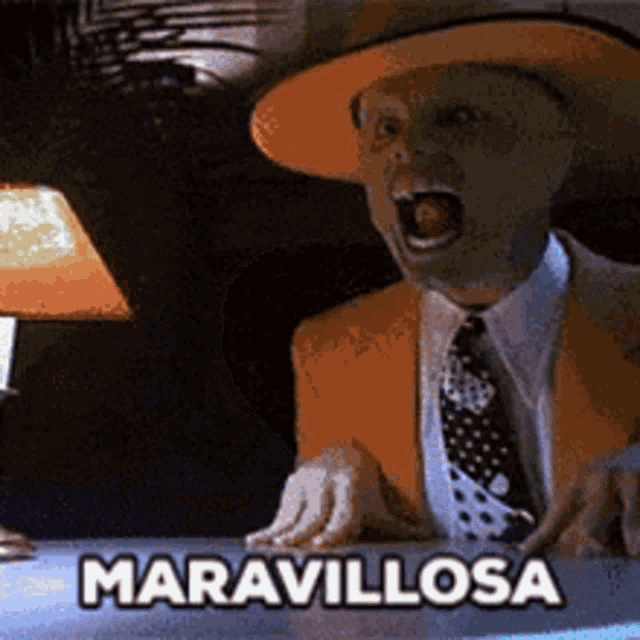 a man in a suit and hat is sitting at a table with the words maravillosa written on the table