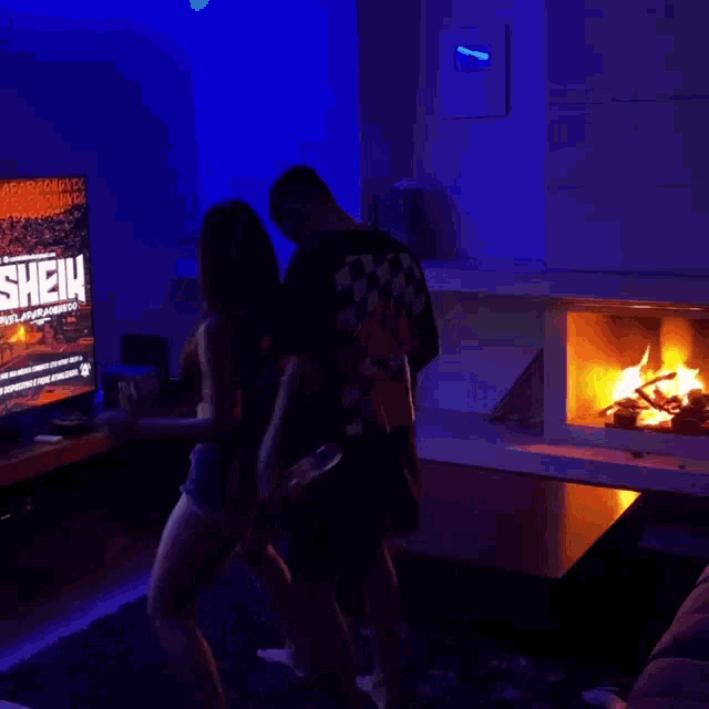 a man and woman are dancing in front of a television that says sheik on it