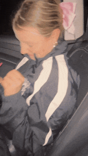 a woman wearing a jacket with a white stripe on the side