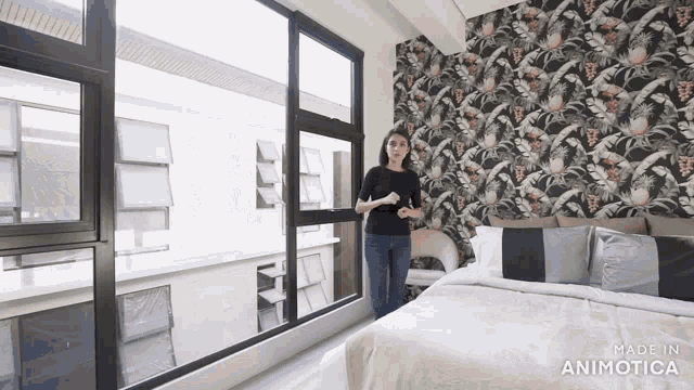 a woman is standing in a bedroom with a floral wallpaper