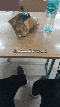 a person sitting at a table with a bag of chips on it