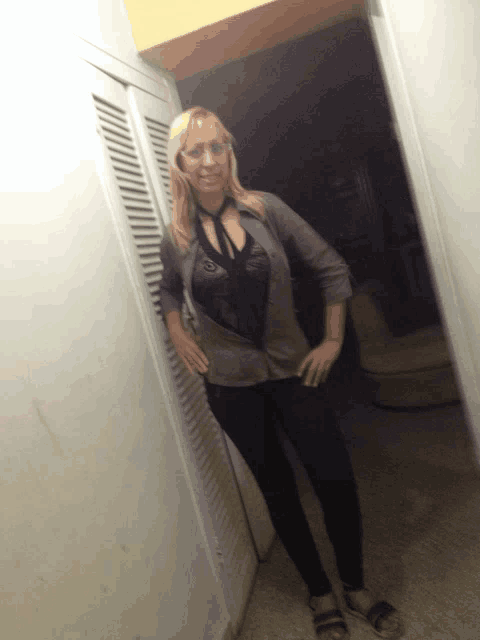 a woman standing in a hallway with her hands on her hip