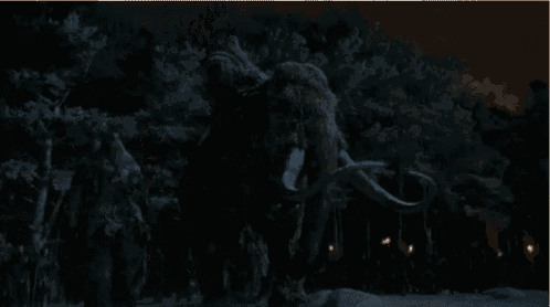 a large elephant is being pulled by a crowd of people in the snow