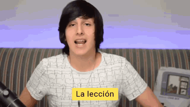 a young man with a yellow sign that says la lección on it