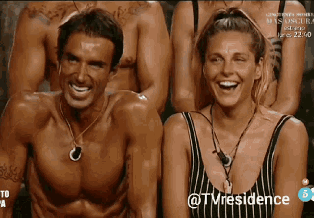a man and a woman are laughing in front of a group of people with the words @tmresidence on the bottom right