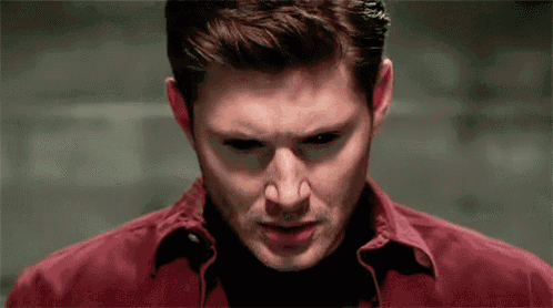 a close up of a man 's face with a red shirt on .