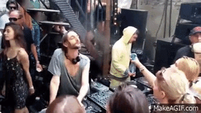 a man is dancing in front of a crowd of people at a party in a club .