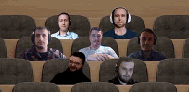 a group of men wearing headphones are sitting in a row of seats
