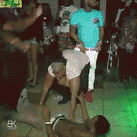 a man in a blue shirt is standing next to a woman dancing on the floor