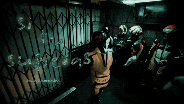 a group of motorcycle riders are standing in front of a gate that says ' suspects '