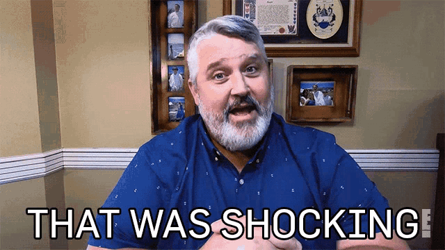 a man with a beard says that was shocking in front of framed pictures