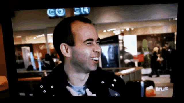 a tv screen shows a man laughing in front of a go sign