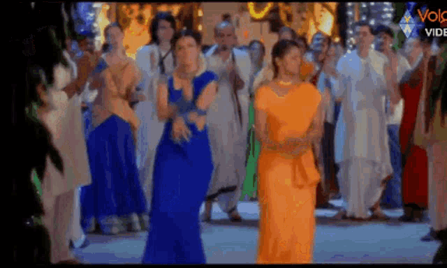 a group of women are dancing in front of a crowd .