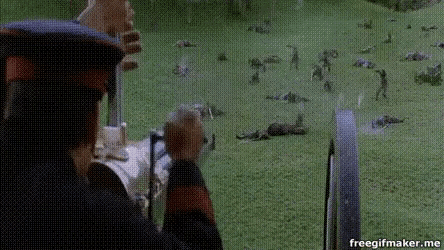a person is holding a gun in front of a field of dead animals .