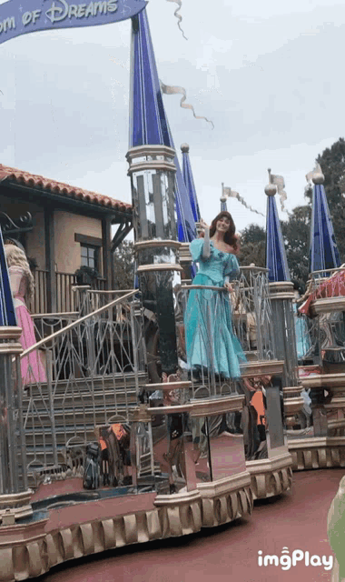 a woman in a blue dress is standing in front of a sign that says " room of dreams "