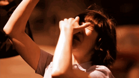 a person covering their face with their hand while looking up