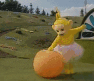 a teletubbies character is playing with a large orange ball .
