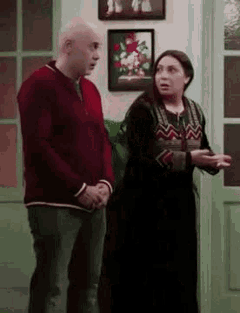 a man and woman are standing next to each other in a room .