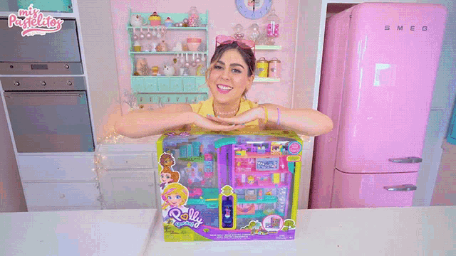 a woman sitting in front of a pink refrigerator with the word aventuras written on it