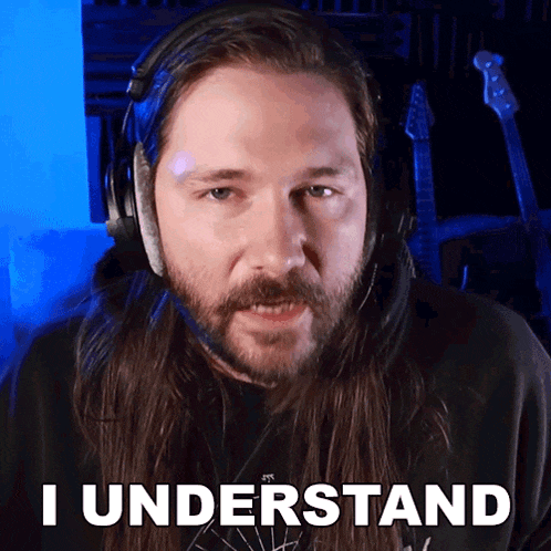 a man with long hair and a beard is wearing headphones and says i understand