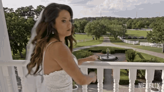 a woman in a wedding dress is standing on a balcony with a netflix logo in the corner