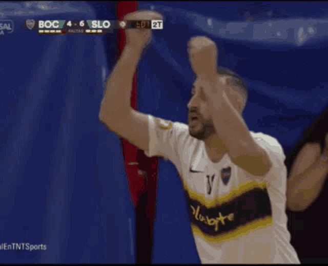 a man wearing a jersey with the number 15 on it holds his arms in the air