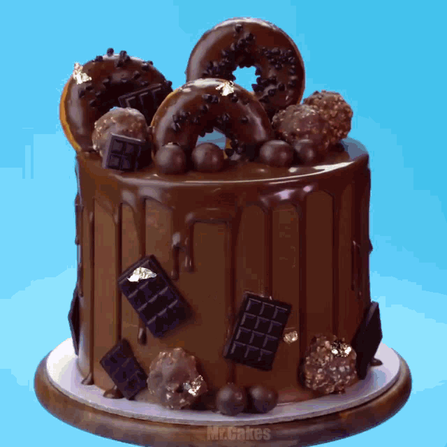 a chocolate cake with donuts and chocolate bars on top of it