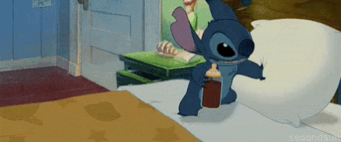 stitch from the movie lilo and stitch is holding a bottle of milk and standing on a bed .