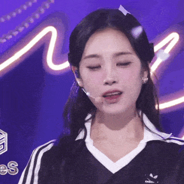 a close up of a girl wearing an adidas shirt