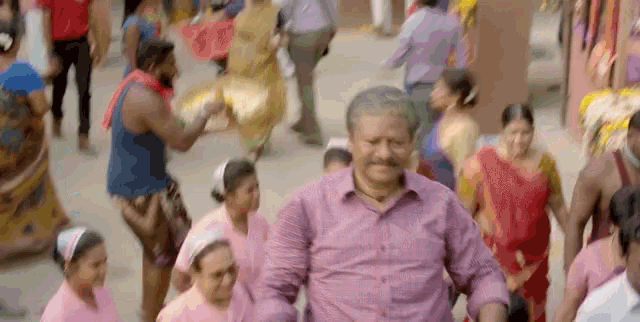 a man is walking through a crowd of people on a street .