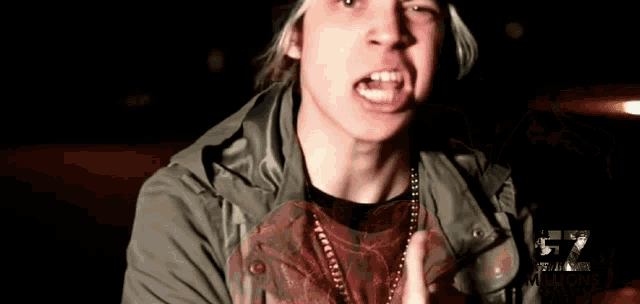 a man wearing a hat and a necklace with the number 57 on his chest