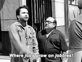a black and white photo of two men standing next to each other with the words `` where jobs grow on jobbles ! ''