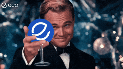a man in a tuxedo is holding a wine glass in front of a circle with the letter e in it