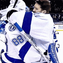 a hockey player with the number 88 on his jersey is hugging another player