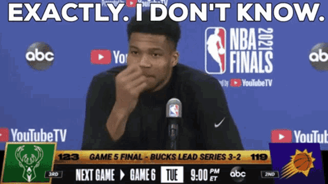 a man speaking into a microphone in front of a screen that says nba finals
