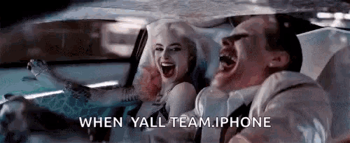 a man and a woman are sitting in a car laughing .