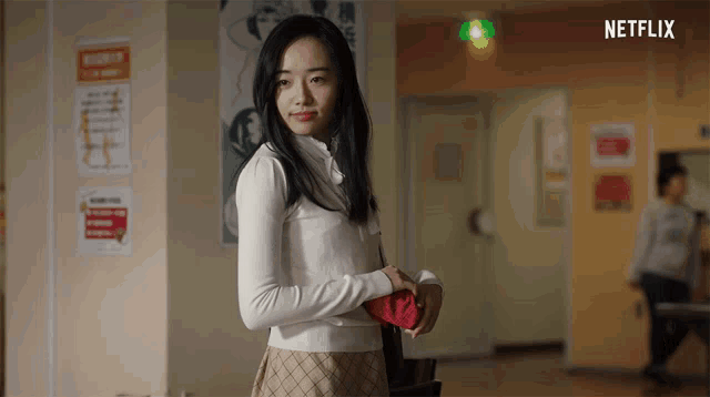 a woman is standing in a hallway with a sign that says netflix