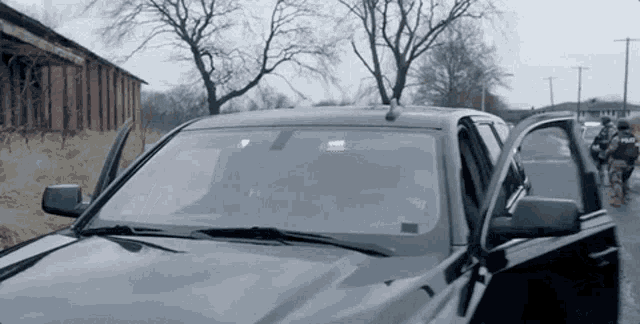 a black police car is parked on the side of a road .