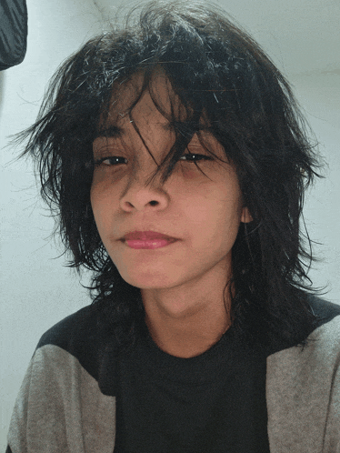 a young girl with a striped shirt and a messy haircut