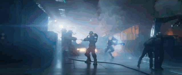 a group of soldiers are standing in a dark room with smoke coming out of it .