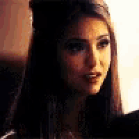 a close up of a woman 's face with long hair and a serious look on her face .