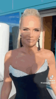 a woman in a black strapless dress and earrings is smiling .