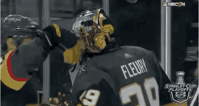 a hockey player wearing a helmet and a jersey with the number 20 on it is standing next to another hockey player .