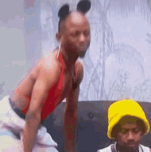 a man in a mickey mouse costume is dancing on a couch .