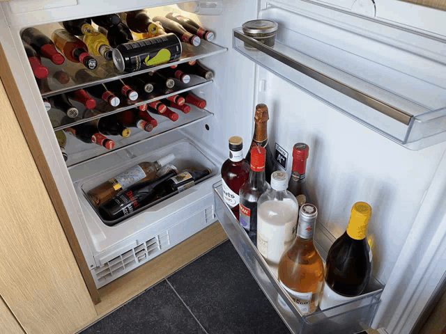 a fridge filled with bottles of alcohol including a bottle that says ' smirnoff ' on it