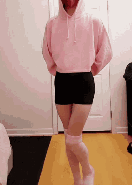 a woman wearing a pink hoodie and pink socks