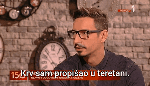 a man with glasses and a beard is on a tv screen with the words krv-sam-propisao-u-teretani