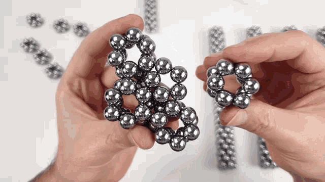 a person holding a bunch of metal beads in their hands
