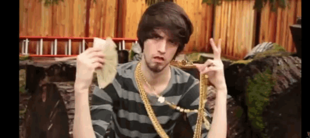 a man wearing a striped shirt and gold chains holds a tortilla in his hand